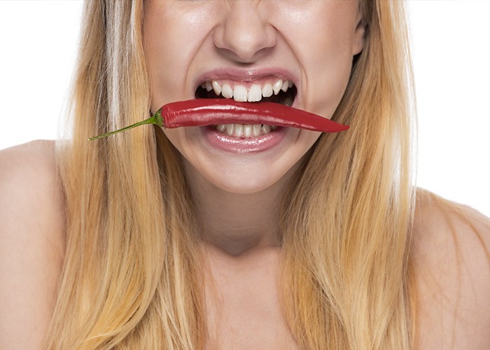 Frau mit Chili im Mund